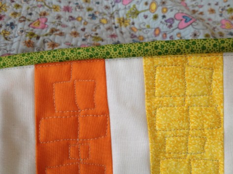 Stitches trace the edge of the quilt just inside the binding: perfect!
